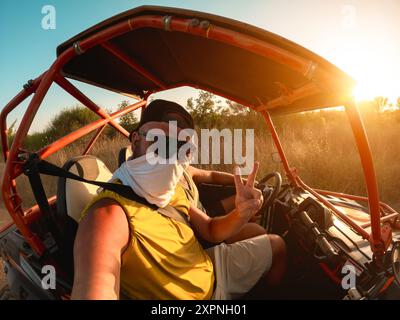 Men tourist having fun doing selfie during summer buggy tour - Travel, vacation and wild experience concept - Main focus on male face Stock Photo