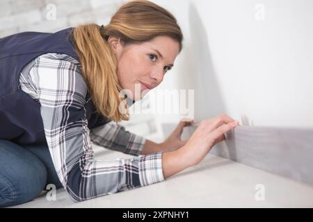 female builder working on flooring Stock Photo