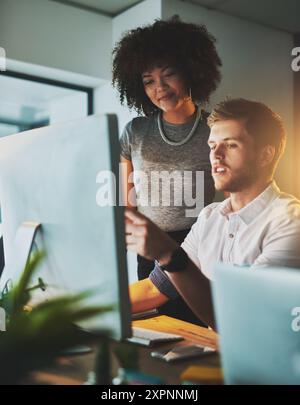 Creative people, designers and night with computer at office for online project, web or collaboration. Businessman and woman working late together on Stock Photo