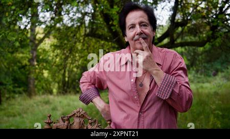 Handsome man holding an index finger to his mouth, considering what to do. Stock Photo
