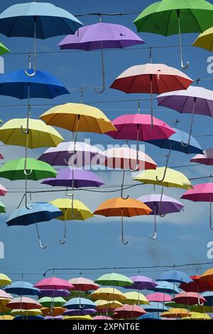 Loads of colorful umbrellas against blue sky. Stock Photo