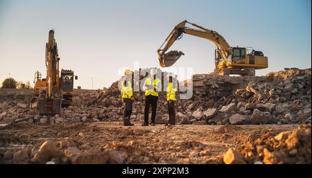 Construction Site With Excavators on Sunny Day: Diverse Team Of Male And Female Specialists Discussing Real Estate Project. Civil Engineer, Architect And Investor Talking About Apartment Building. Stock Photo