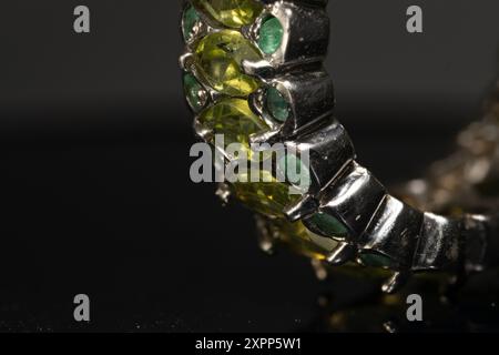 silver ring with emeralds and peridots on background Stock Photo