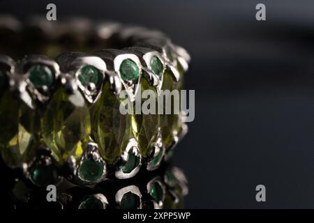 silver ring with emeralds and peridots on background Stock Photo