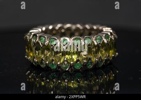 silver ring with emeralds and peridots on background Stock Photo