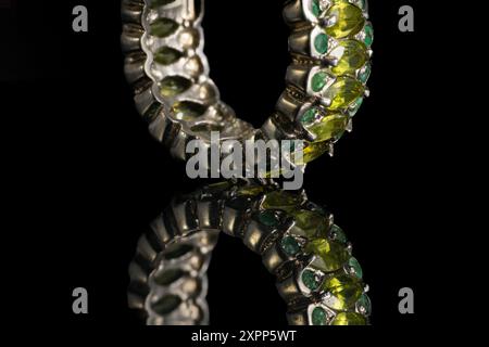 silver ring with emeralds and peridots on background Stock Photo