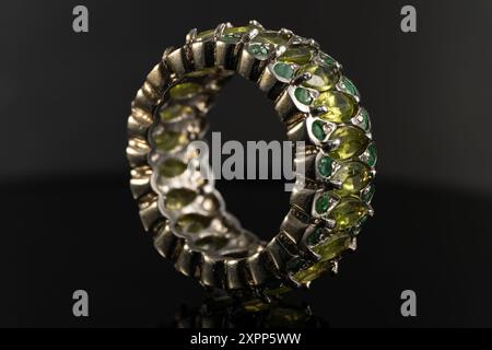 silver ring with emeralds and peridots on background Stock Photo