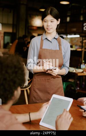 Waitress Taking Order from Customer in Cozy Restaurant Stock Photo