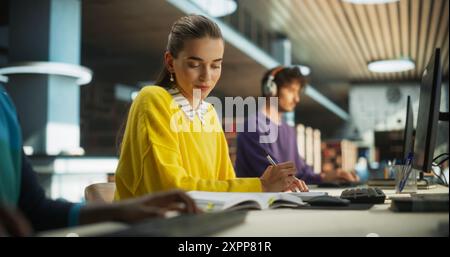 Portrait of an Enthusiastic Female Working on a Computer with a Group of University Students. Smart Young People Preparing Homework Assignments and Studying for Exams in a College Library Stock Photo