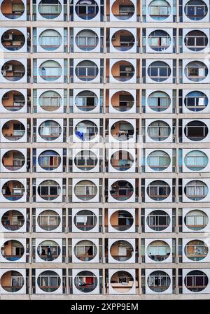 Repeated pattern of a high buidling facade with windows and frame in crowded urban life for low income classes Stock Photo
