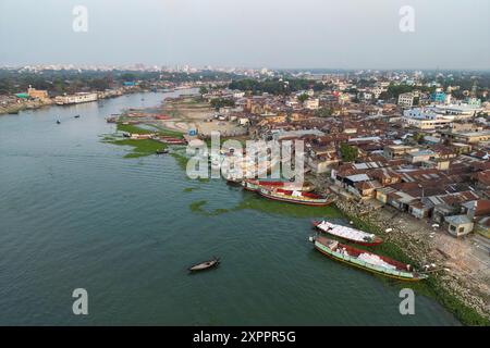 Aerial of fishing boats moored alongside Dakatiya river with river cruise ship RV Thurgau Ganga Vilas (Thurgau Travel) in distance, Chandpur, Chandpur Stock Photo