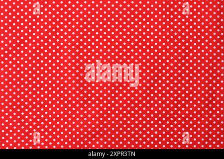 Bright red fabric material with a white polkadot pattern. Backgrounds. Stock Photo