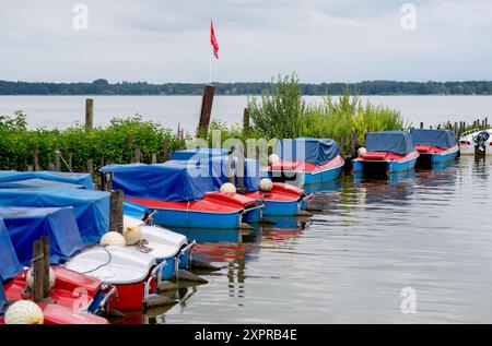 Bad Zwischenahn, Germany. 07th Aug, 2024. Numerous electric boats are covered up on a jetty in the Zwischenahner Meer in cloudy weather. Credit: Hauke-Christian Dittrich/dpa/Alamy Live News Stock Photo