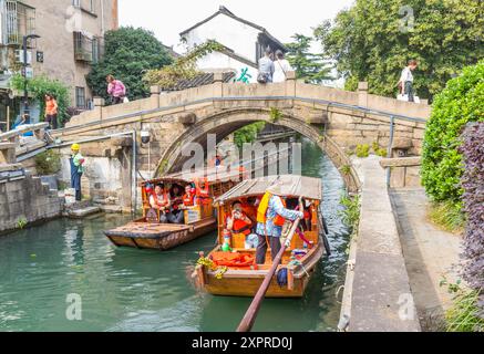 Traditional wooden boats under the historic bridge in Suzhou, China Stock Photo