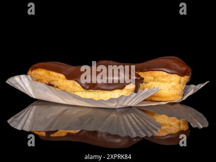 Two eclairs with cream, macro, isolated on a black background. Stock Photo