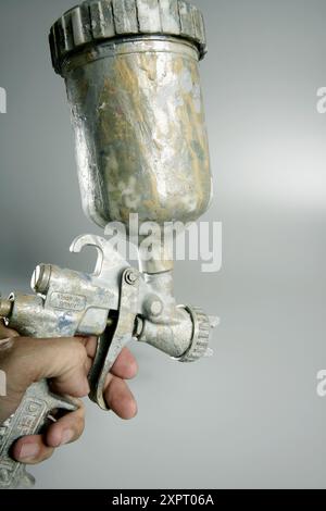 Silver paint air gun in operators hand Stock Photo
