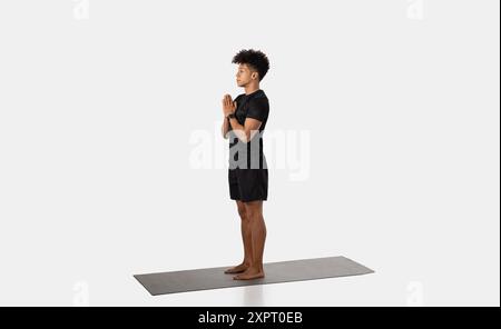 Man Practicing Yoga in Mountain Pose on Mat in Studio Stock Photo