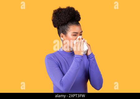 Woman Sneezing Into Tissue While Wearing Purple Long Sleeve Stock Photo