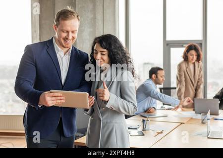 Business Professionals Collaborating On Tablet In Modern Office Stock Photo