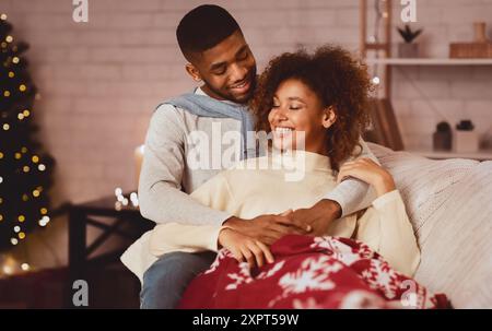Enjoy winter holidays together. Loving couple relaxing on sofa Stock Photo