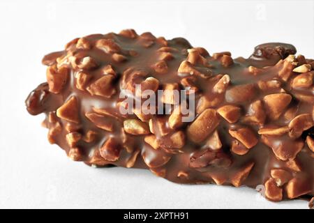 Piece of sweet bar with nuts covered with chocolate isolated on white background Stock Photo