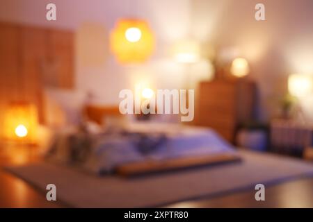 Blurred view of bedroom with glowing lamps and commode Stock Photo
