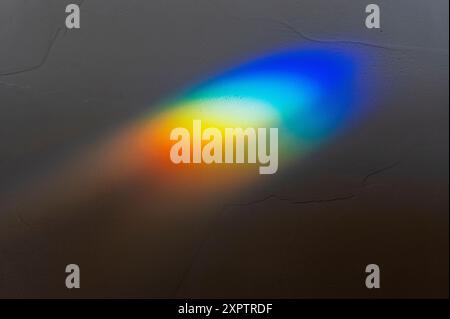 Refracted sunlight through stained glass window creates a prism of rainbow colors Stock Photo