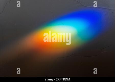 Refracted sunlight through stained glass window creates a prism of rainbow colors Stock Photo