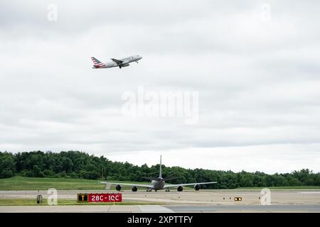 A KC-135 “Stratotanker” aircraft, assigned to the 171st Air Refueling Wing, sits parked along the runway after executing an Alert Aircraft Repositioning Plan (AARP) in support of Exercise Steel Forge, while a commercial airliner takes off overhead, June 9, 2024, Near Pittsburgh, Pennsylvania. Exercise Steel Forge is a multi-wing exercise designed to test the readiness capabilities of service members in a controlled simulated environment. (U.S. Air National Guard photo by Mr. William Shapiro) Stock Photo