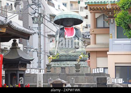 a statue of Ksitigarbha, Jizo Bodhisattva sitting statue at Shinshoji Temple near Sugamo.  Sugamo is a neighborhood in Toshima, Tokyo, Japan. an old- Stock Photo