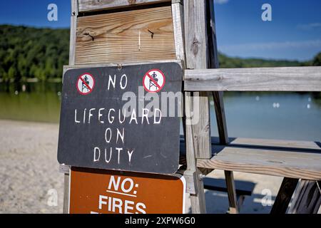 BOONSBORO, Maryland, United States — An old wooden lifeguard stand with a 'No Lifeguard on Duty' sign at Greenbrier Lake near Boonsboro, Maryland. This summer scene captures the rustic charm of the lake area on a sunny day, with the calm waters of the lake visible in the background. Stock Photo