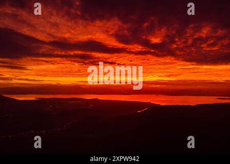 Sunrise or sunset with amazing clouds and silhouette of coastline in Florianopolis, Brazil Stock Photo