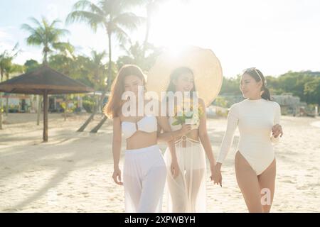 Beautiful Asian girlfriends in white beach wear themes enjoying time together by the beach Stock Photo