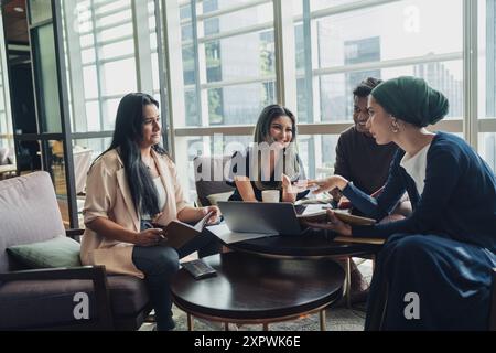 Diverse Asian business executives including a disabled man in wheelchair having a casual meeting Stock Photo
