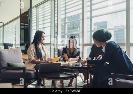 Diverse Asian business executives including a disabled man in wheelchair having a casual meeting Stock Photo