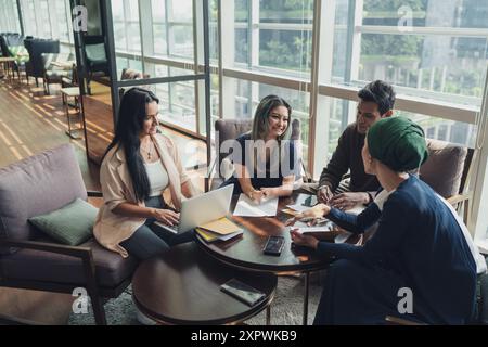 Diverse Asian business executives including a disabled man in wheelchair having a casual meeting Stock Photo