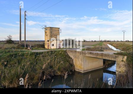 Arles, France - March 23, 2023: Old transformer station at canal near Arles on a sunny evening in winter, blue sky Stock Photo