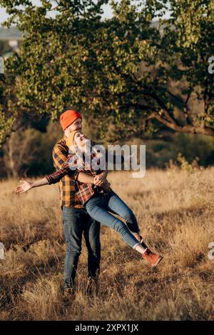 Cheerful guy and girl on a walk in bright knitted hats and plaid shirts Stock Photo