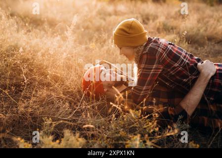 Cheerful guy and girl on a walk in bright knitted hats and plaid shirts Stock Photo