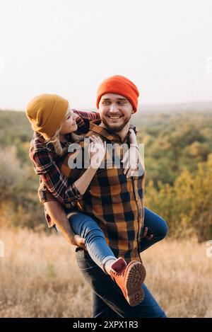 Cheerful guy and girl on a walk in bright knitted hats and plaid shirts Stock Photo