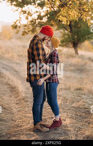 Cheerful guy and girl on a walk in bright knitted hats and plaid shirts Stock Photo