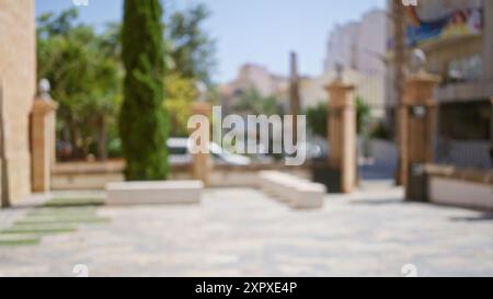 Blurry outdoor park scene with a bokeh effect, showing trees and architecture in an out-of-focus background. Stock Photo