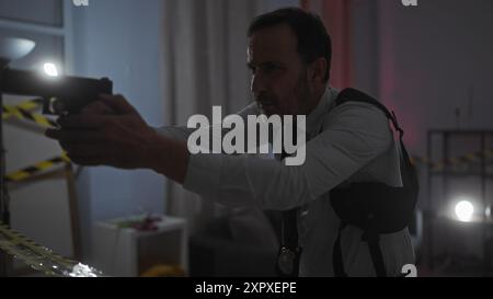 Mature detective man indoor crime gun focus concentration serious Stock Photo