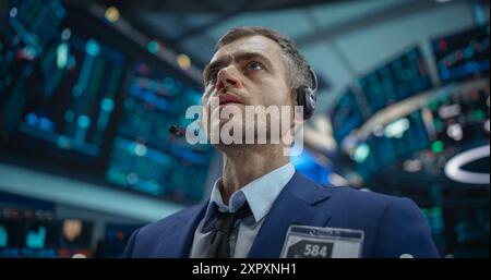 Close Up Portrait of a Smart and Thoughtful Stock Exchange Broker. Adult Man in Looking at Computer Screens, Analyzing Stock Exchange Market Data, Brainstorming a Successful Buying Strategy Stock Photo