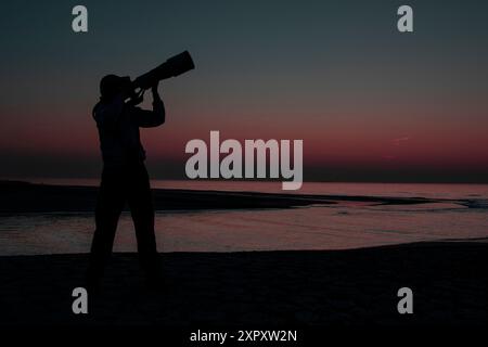 photographer on the North Sea beach in the dark, Netherlands, South Holland, Katwijk Stock Photo
