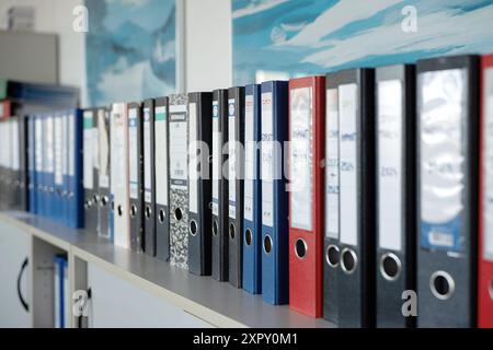 Row of used office folders or binders on a shelf. Close up shot, shallow depth of field, no people. Stock Photo
