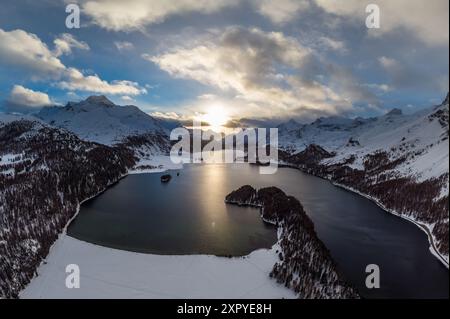 Dramatic sunset over the lake Sils in winter in the Engadine valley near Silvaplana and St Moritz in Canton Graubunden in the Swiss alps. Stock Photo