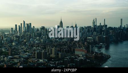 New York City Skyline at Sunset. Aerial Shot of Manhattan from a Helicopter. Panoramic View from the Side of East Village and Generating Station Power Plant on East River Stock Photo