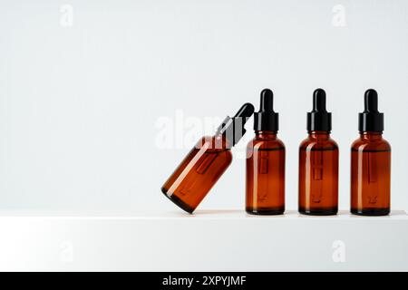 Row of various brown glass dropper bottles isolated on white background Stock Photo