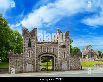 The gatehouse, an 18th-century modification to the castle in  Castlebellingham, with St Mary’s Church, County Louth, Ireland. Stock Photo